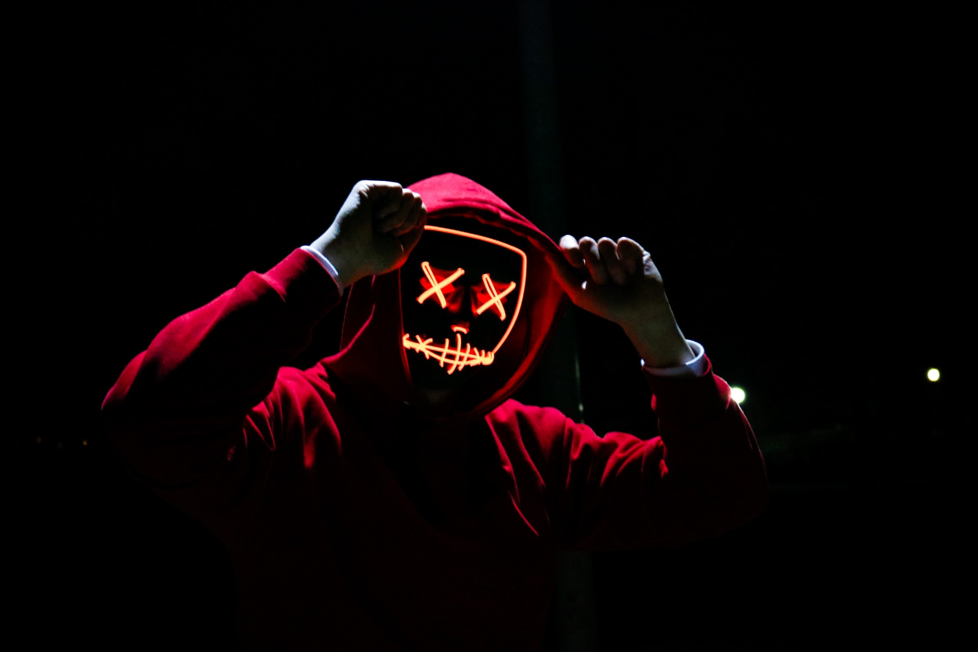 A person with a hoodie and in the dark